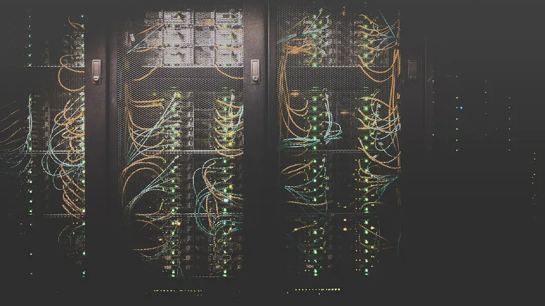 Zdjęcie przedstawia serwerownię z licznymi szafami serwerowymi, podświetlonymi kolorowymi diodami i okablowaniem. Otoczenie wskazuje na zaawansowane technologicznie środowisko związane z centrami danych i infrastrukturą IT. — Zdjęcie: Taylor Vick
